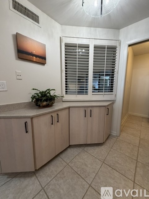 A kitchen with wooden cabinets and a painting on the wall.