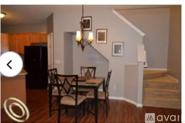 A dining room with a wooden table and chairs.