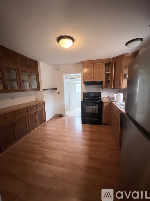 A kitchen with wooden cabinets and a refrigerator.