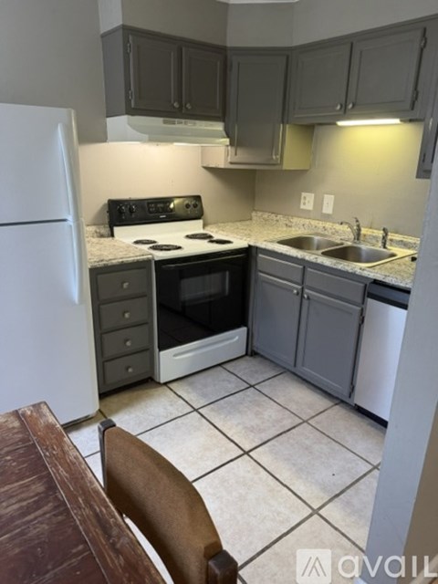 A kitchen with a white refrigerator and a white dishwasher.
