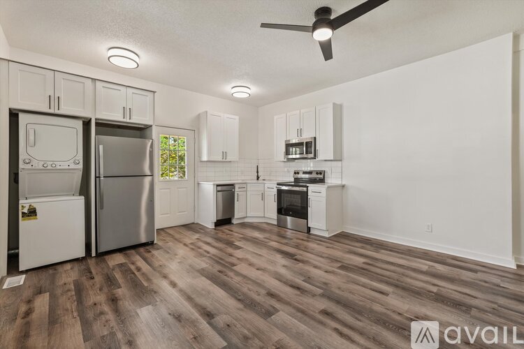 A kitchen with a refrigerator, oven, and stove top.