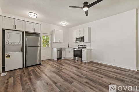 A kitchen with a refrigerator, oven, and stove top.