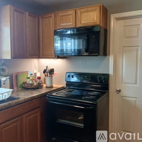A kitchen with a black microwave above a stove.