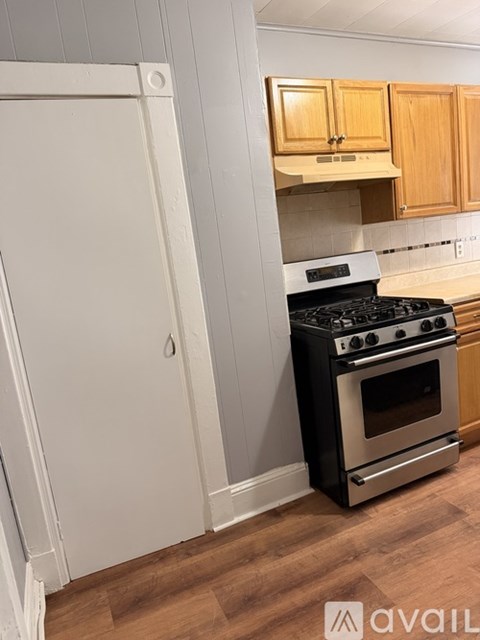 A black stove in a kitchen with wooden cabinets.