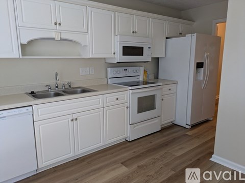 A kitchen with white cabinets and appliances.
