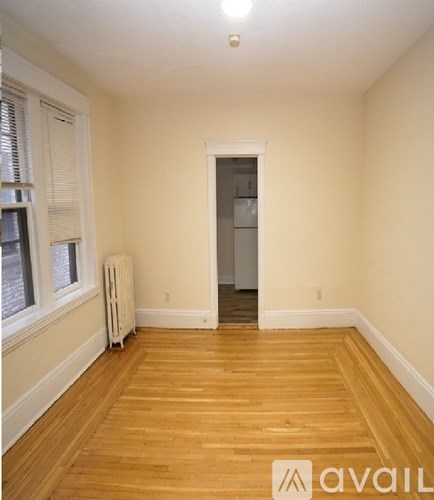A room with wooden floors and a white wall.