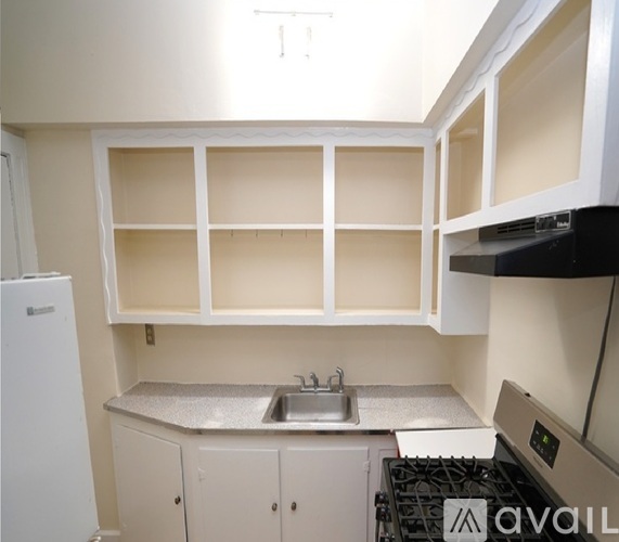 A kitchen with a white fridge, a stove, and a sink.