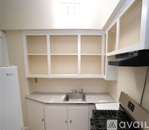 A kitchen with a white fridge, a stove, and a sink.