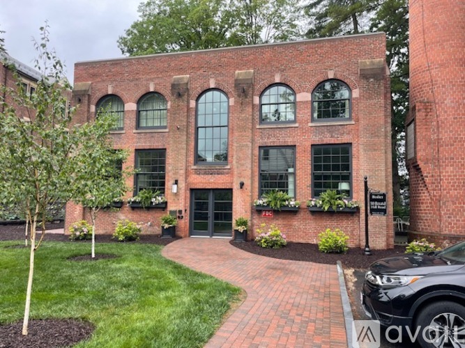 A red brick building with a green lawn in front.