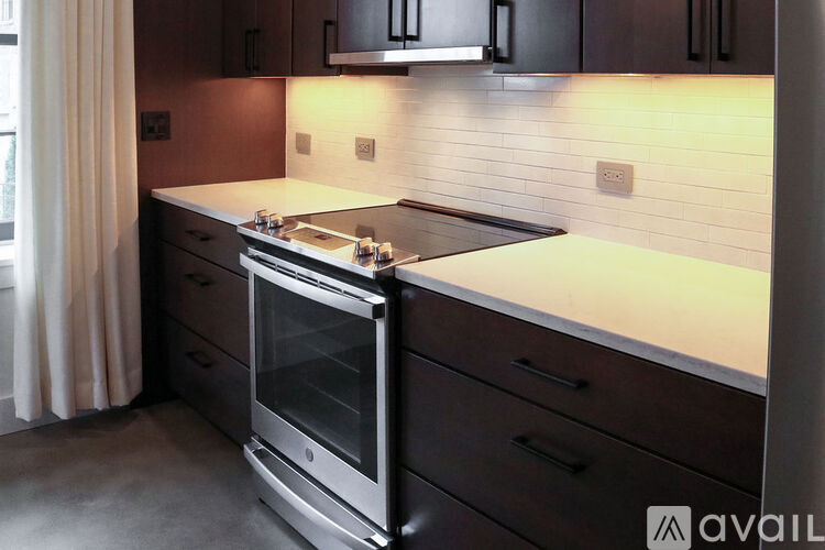 A modern kitchen with dark wood cabinets and a stainless steel oven.