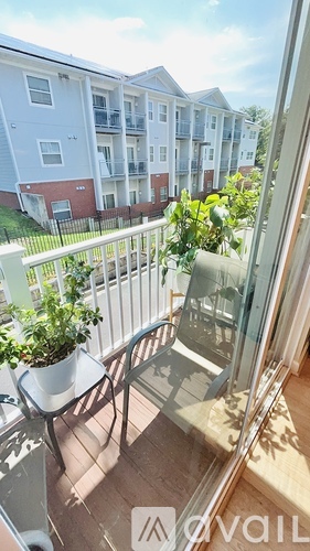 A balcony with a table and chairs overlooking a building.