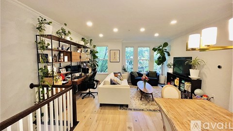 A living room with a white couch and a wooden floor.