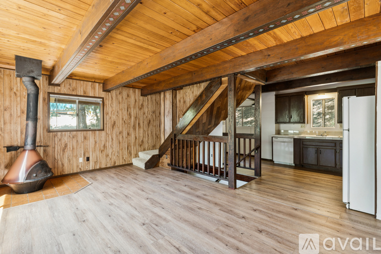 A wood stove is in the corner of a large open living room.
