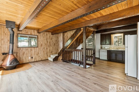 A wood stove is in the corner of a large open living room.