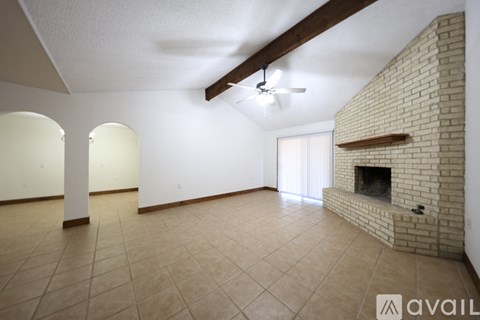 A living room with a fireplace and a ceiling fan.