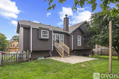 A house with a grey exterior and a brown roof with a chimney.