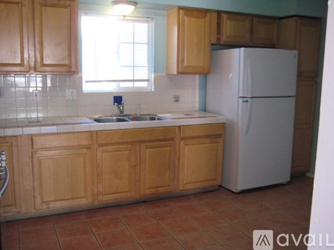 A kitchen with wooden cabinets and a white refrigerator.