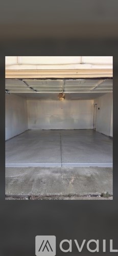A spacious garage with a concrete floor and white walls.