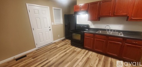 A kitchen with wooden floors and red cabinets.