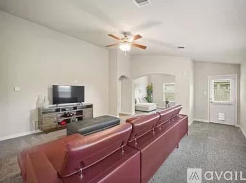 A living room with a red couch and a television.