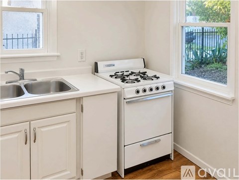 A white kitchen with a stove and sink.