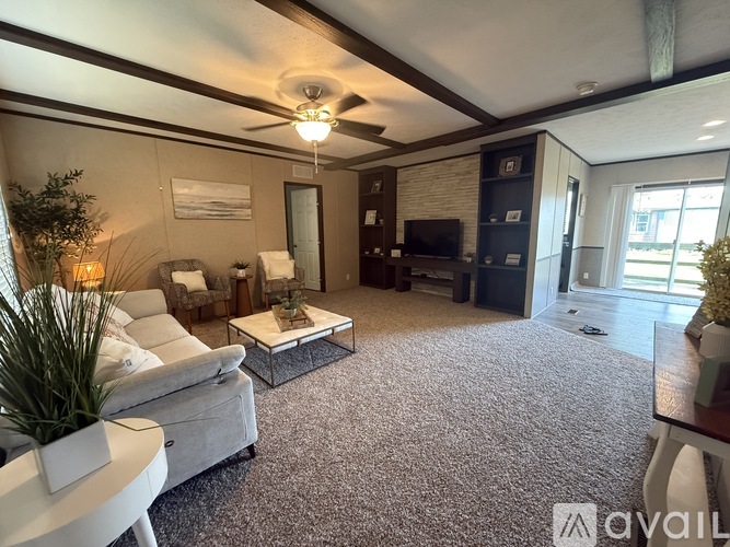 A living room with a white couch, a coffee table, and a ceiling fan.