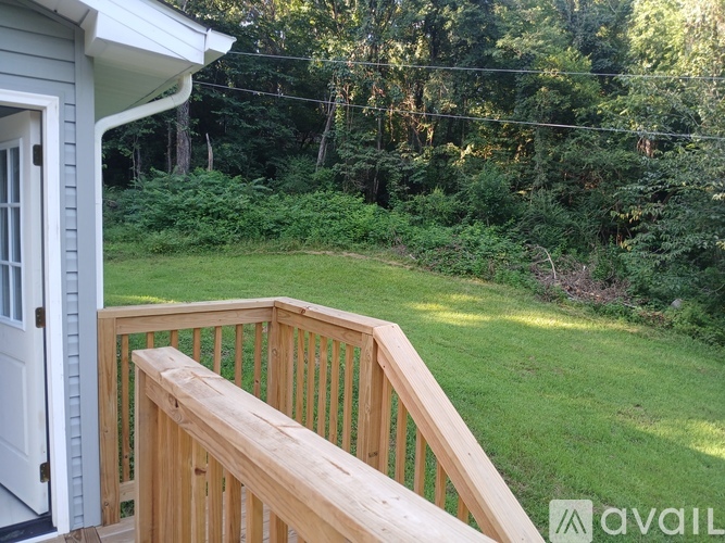 A wooden deck with a white door and a green lawn.