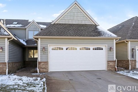A house with a garage and a driveway in front of it.