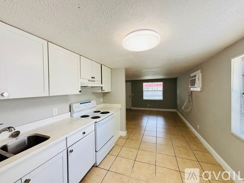 A kitchen with white cabinets and a stove top oven.