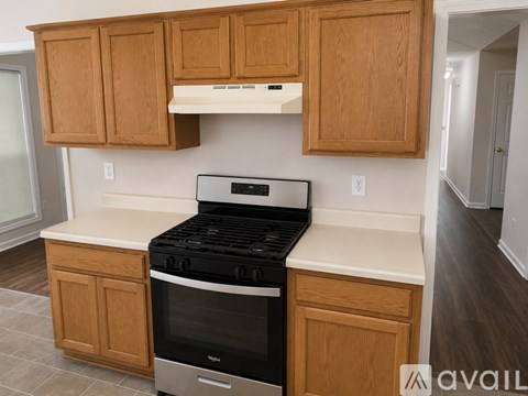 A kitchen with wooden cabinets and a black stove top oven.