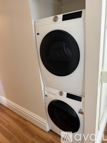Two white front loading washing machines in a laundry room.