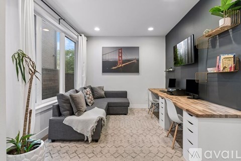 A living room with a grey couch and a wooden table.