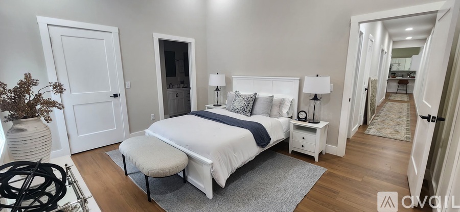 A bedroom with a large bed and a bench in front of it.