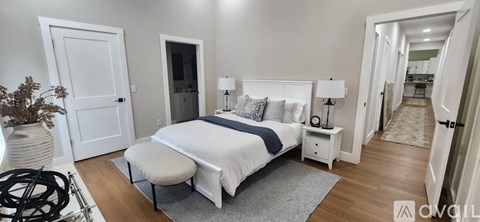 A bedroom with a large bed and a bench in front of it.