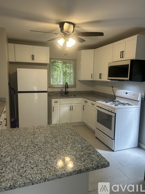 A kitchen with granite countertops and white appliances.