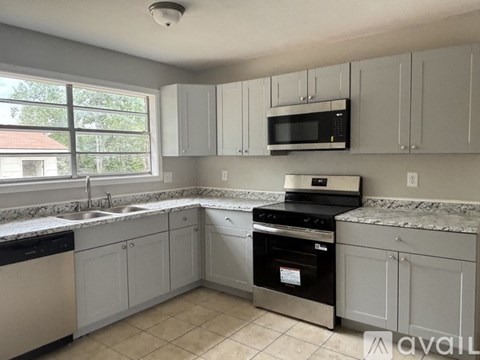 A kitchen with white cabinets and a black oven.