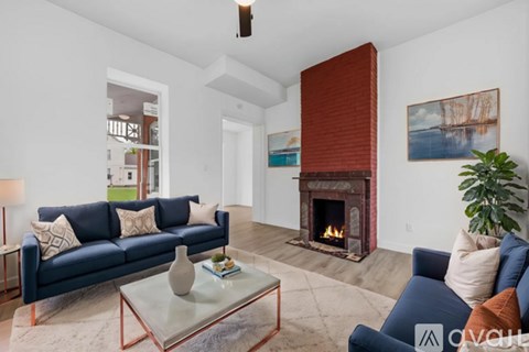 A living room with a blue couch and a fireplace.