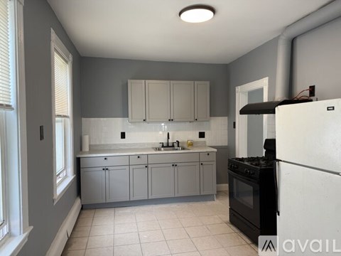 A kitchen with a black stove top oven and white cabinets.