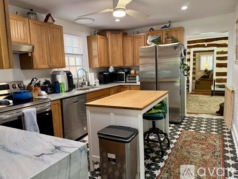 A kitchen with wooden cabinets and a marble countertop.