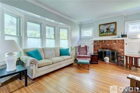 A living room with a white couch and a fireplace.