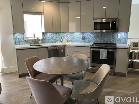 A kitchen with a table and chairs in the middle of it.