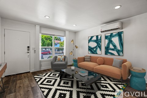 A living room with a brown sofa and a black and white rug.