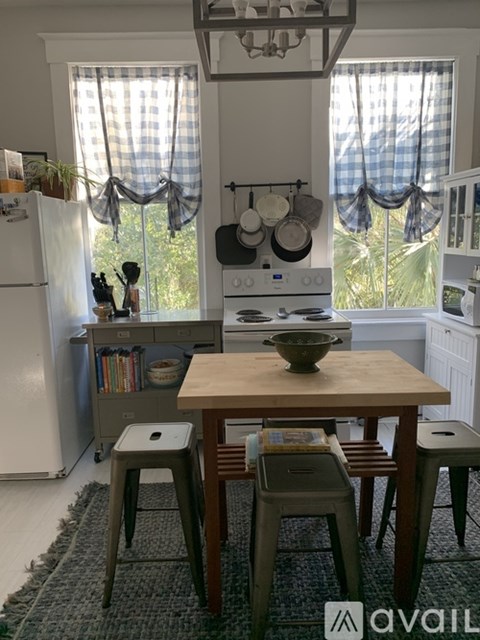 A kitchen with a table and chairs in front of a window.