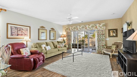 A living room with a red chair and a glass table.