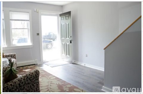 A living room with a couch and a door leading outside.
