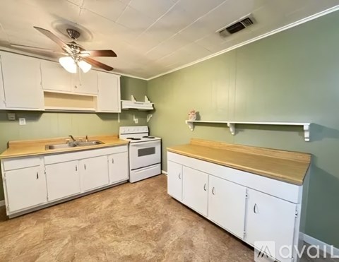 A kitchen with white cabinets and a wooden countertop.