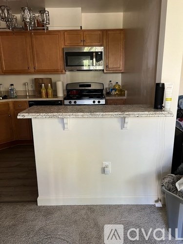 A kitchen with a white island and wooden cabinets.