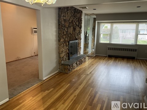A living room with a television and a stone wall.