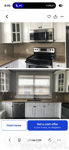 A kitchen with a black stove top oven and white cabinets.