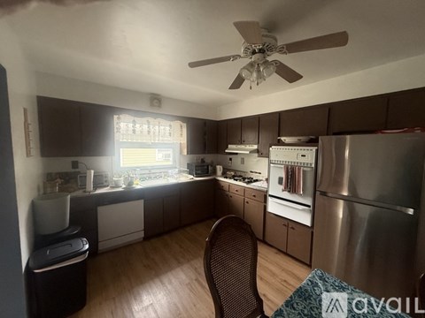 A kitchen with a refrigerator, sink, and stove.